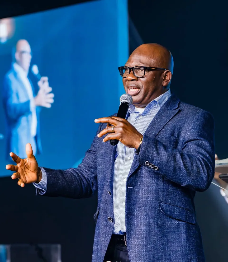 Pastor David Adeosun teaching with a microphone in a blue blazer at Kingdom Stars Assembly in Guelph