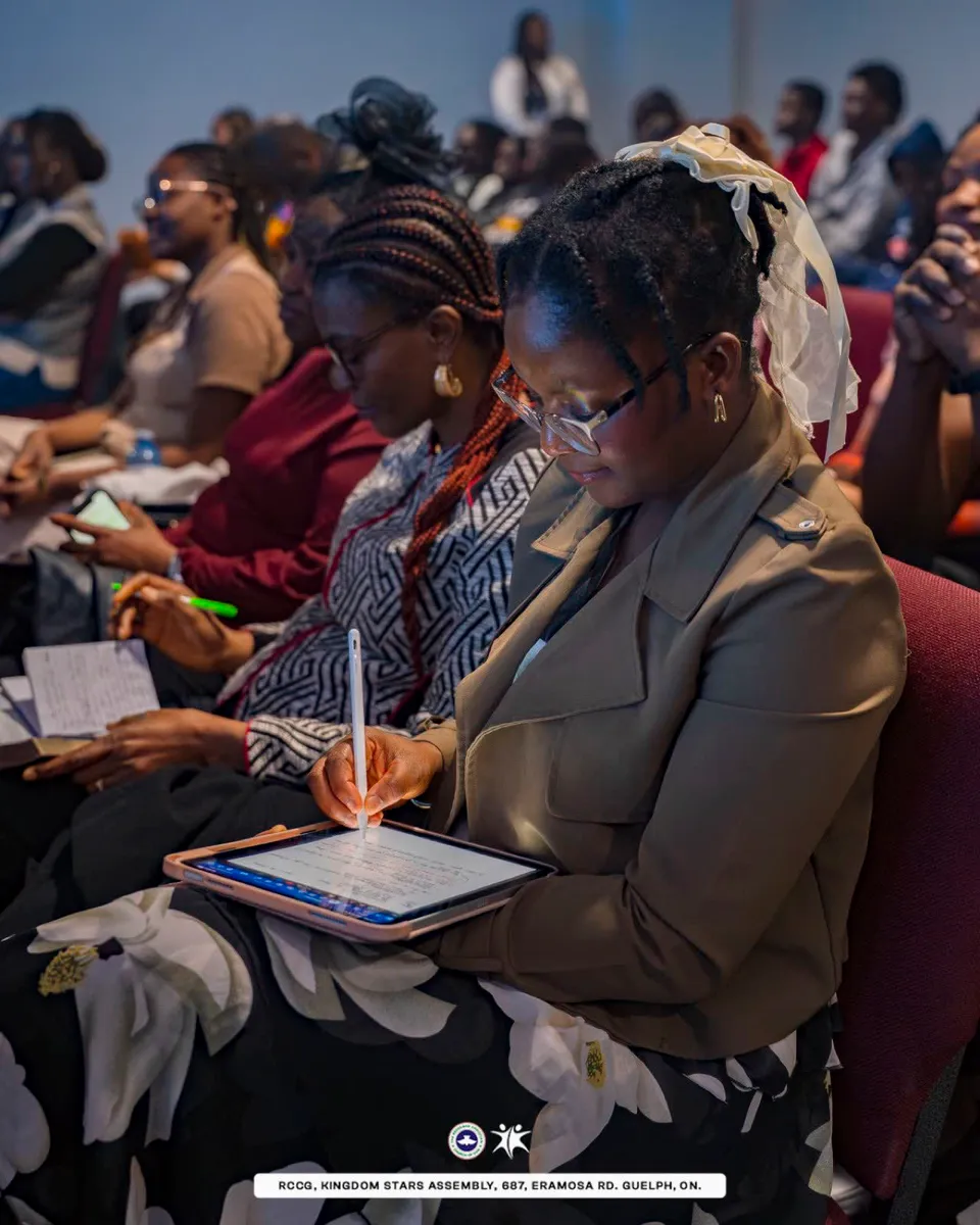 Young woman seated in the congregation at Kingdom Stars Assembly Guelph writing notes on a tablet during service